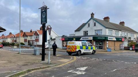 A police van and officer outside Morrisons Daily on Salisbury Road, Great Yarmouth, Norfolk