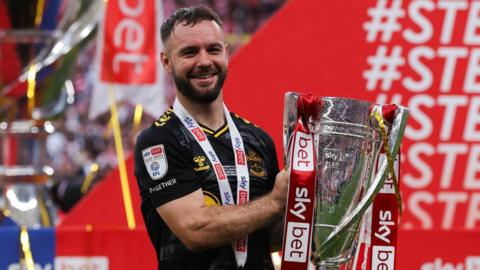 Adam Armstrong poses for a photo while holding the Championship play-off trophy