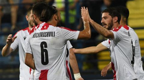 Georgia players celebrate scoring a goal against Montenegro