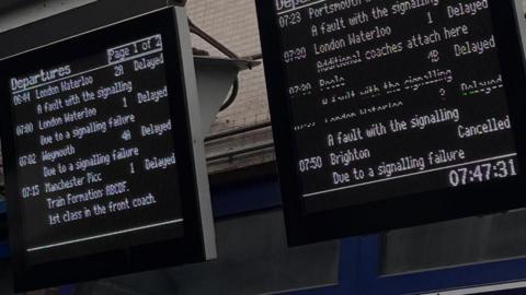 A digital train departure board at Southampton Central. All services have 'delayed' or 'cancelled' next to them.