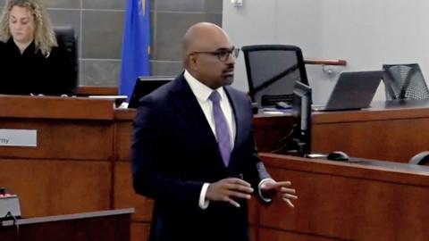 Binu Palal wears a black suit in a courtroom.