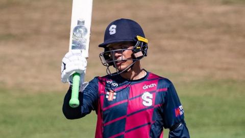 Stuart van der Merwe raises his bat after reaching his half-century against Sussex