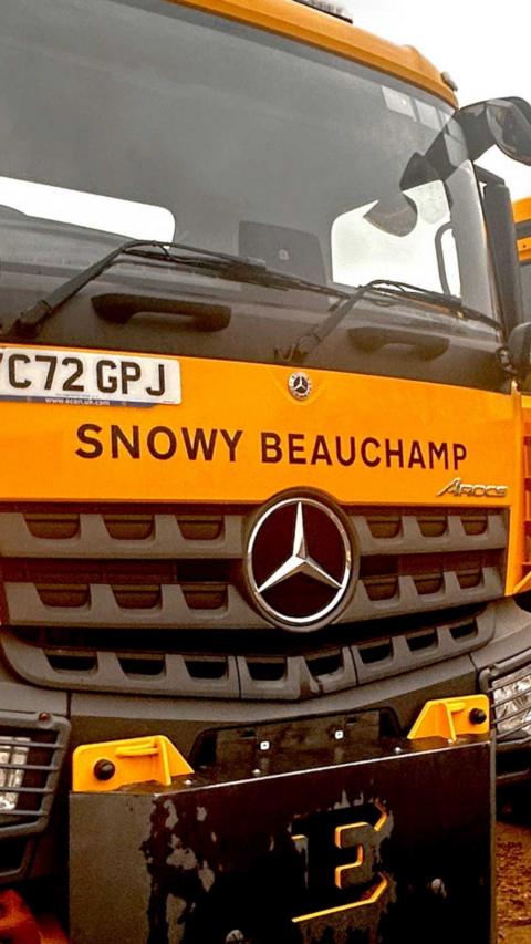 A yellow lorry with the name Snowy Beauchamp written on it.