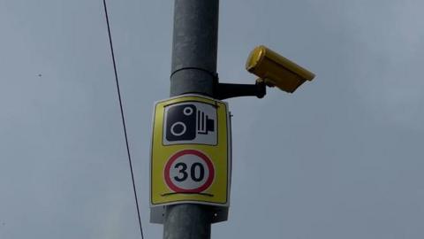 A yellow fake camera fitted to a lamp post on London Road, Sleaford