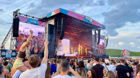 The crowd cheers at Big Weekend as fires comes from the stage