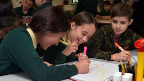 Children writing in a classroom