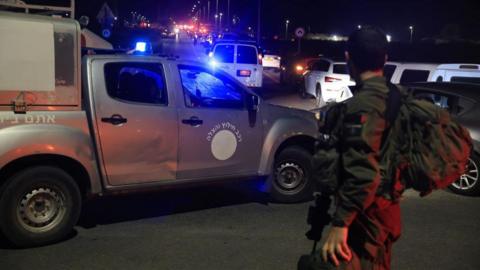 An Israeli soldier watches an ambulance in Binyamina 