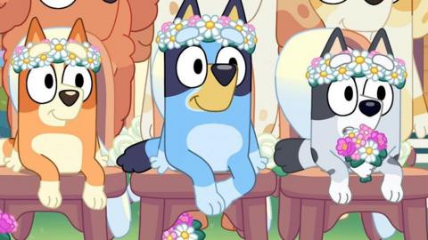 Bluey the dog sitting next to other characters from the animated series. 