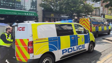 Two police vans parked outside of a McDonalds 