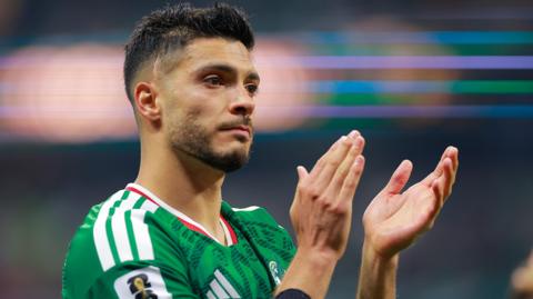 Raul Jimenez, wearing Mexico's green shirt with white Adidas stripes and a white and red collar, looks dejected as he claps his hands after Mexico's 3-2 defeat to England in the last-16 of the World Cup