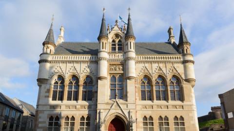 Inverness Town House has a victorian gothic style with narrow turrets on the roof and large elegant windows