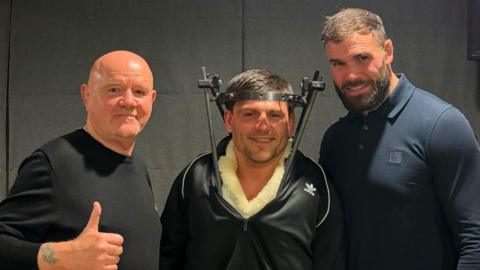 James Newton (centre) with a man on either side of him