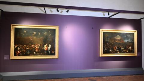 The wall of the Uffizi Gallery without the painting Portrait of Ferdinando de' Medici Grand Prince of Tuscany by Anton Domenico Gabbiani. Two large paintings remain on the purple wall with a gap between them.