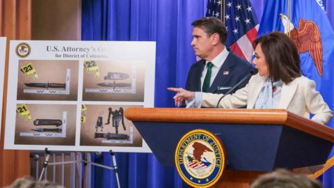 US officials point to a poster showing several kinds of weapons.