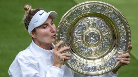 Marketa Vondrousova kisses the Venus Rosewater Dish at Wimbledon in 2023 