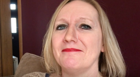 A close up of Jayne looking into the camera.She has short blonde hair and is wearing red lipstick