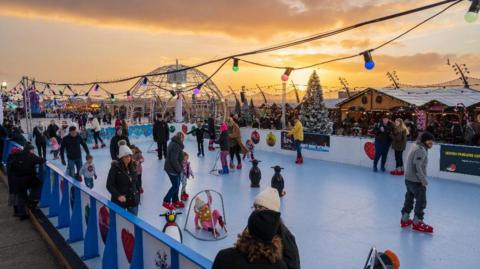 Families wearing winter clothing enjoy themselves on the skating rink at the Christmas by the Sea festival in Blackpool.