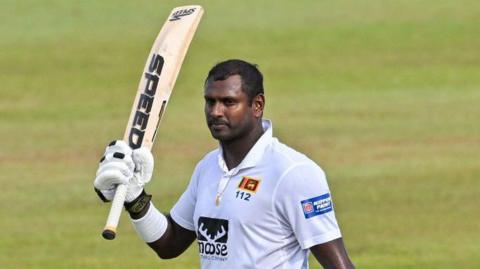 Angelo Mathews raising his bat. 