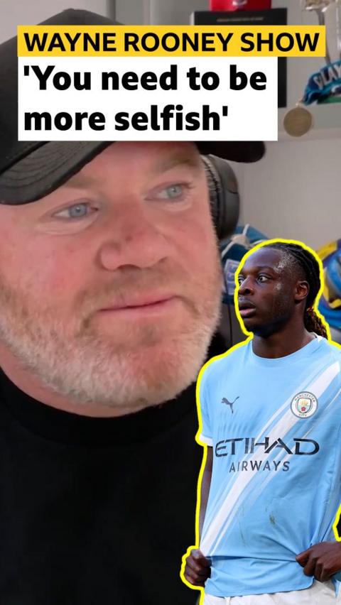 Wayne Rooney looks at a cut out of Jeremy Doku