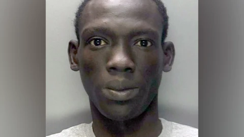 A police mugshot of Deng Majek. He is wearing a light t-shirt