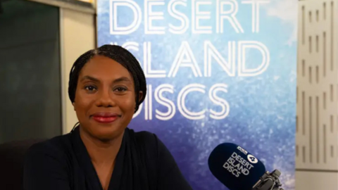 Kemi Badenoch, dressed in black, sitting in the Desert Island Discs studio
