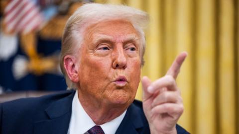 US President Donald Trump with an executive order during a signing ceremony in the Oval Office of the White House in Washington, DC, US, on Monday, Jan. 20, 2025.