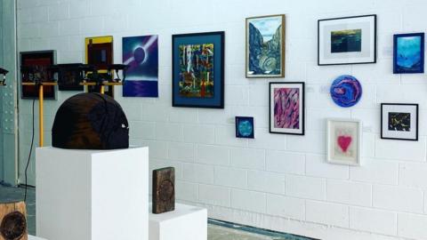 A photo of the gallery and paintings on the wall