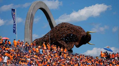 Fans watch on from the grandstand under the bull statue at the Red Bull Ring