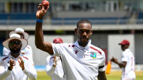 West Indies all-rounder Justin Greaves holds the ball aloft as he is clapped off the field by his team-mates in Trinidad