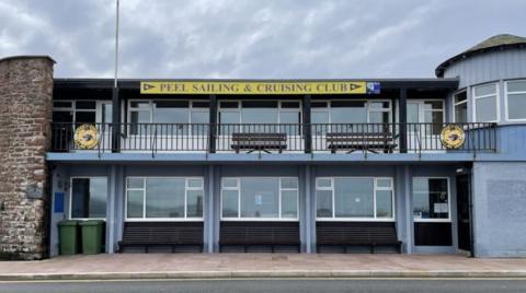 The blue building with a sign saying Peel Sailing and Cruising Club