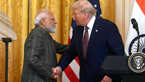 Donald Trump shaking hands with Narendra Modi at a press event