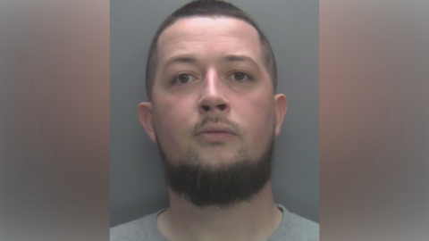 Custody photo of 30-year-old man with short hair and grey t-shirt