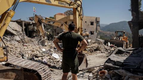 A man looks at destroyed houses amid ongoing search for survivors, a day after an Israeli strike on residential buildings in Maaysrah, north of Beirut, Lebanon