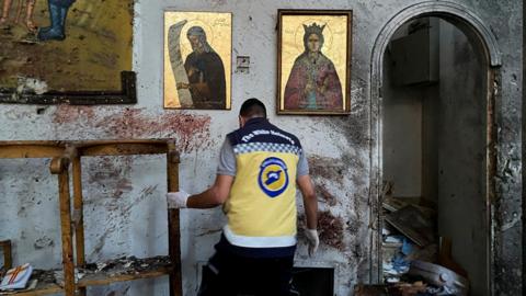 A member of the Syria Civil Defence inspects damage following a suicide bomb attack at the Mar Elias Church in Dweila, a suburb of Damascus, Syria (22 June 2025)