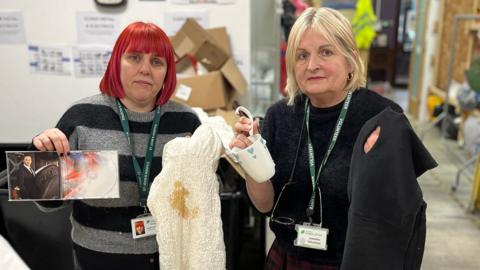 Volunteers holding broken and stained items