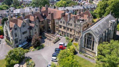 A wide shot of the 15A Magdalen Road site - which is made up of large stone buildings.