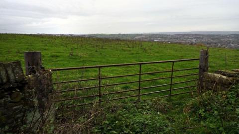 An empty field where the homes are proposed to be built.