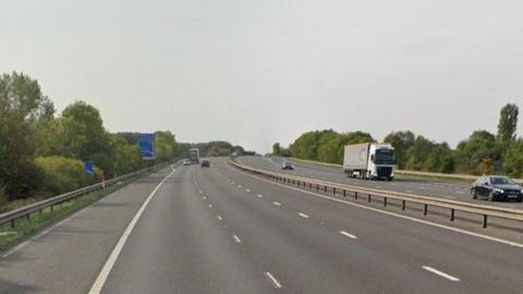 A picture of the M18 motorway showing both sides of the motorway surrounded by trees and greenary 