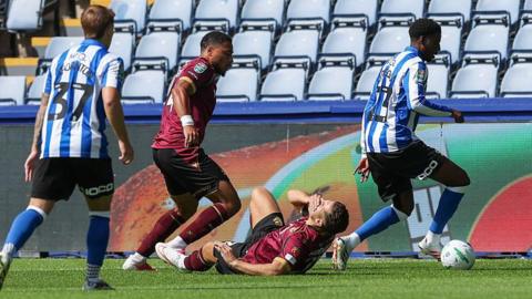 Bolton striker Ruben Rodrigues clutches his face as he lies on the turf