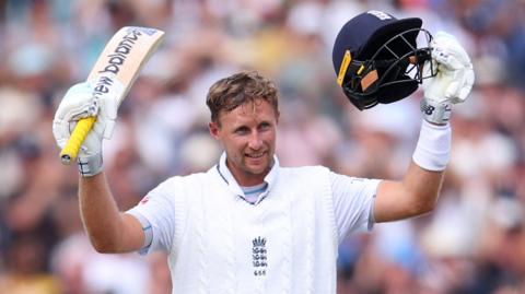 Joe Root raises his bat after scoring a century for England at Old Trafford