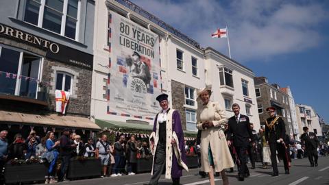 The Princess Royal, accompanied by Vice Admiral Sir Tim Laurence (second row, right), during a visit to St Peter Port, as they attend commemorations in Guernsey 