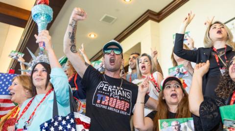 A group of people cheer loudly at the CPAC event in Texas.