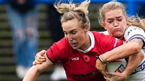 Beth Dainton on Wales is tackled against England
