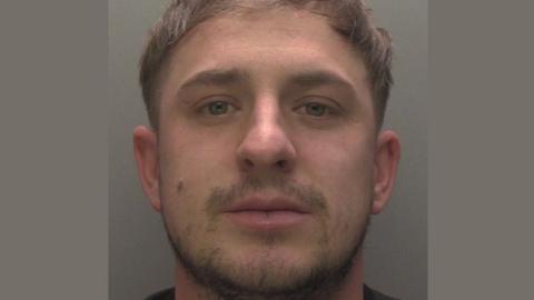 Police mugshot of Connor Whiteley with moustache and beard