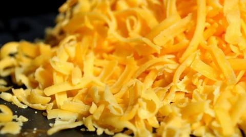 A heap of orange grated cheese close-up