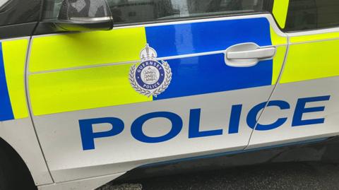 A close-up of a police car showing the word 'police' in large letters along the side.