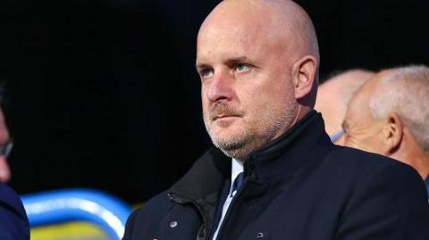 Outgoing Huddersfield Town chief executive officer Jake Edwards watches on from the stands during a League One match