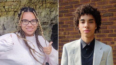 Giselle Prosper smiling with her thumbs up, wearing dark framed glasses and her dark hair in dark and fair dreads, standing, wearing a pink jumper on the left and Kyle Prosper looking serious, with dark curly short hair, wearing gold studs, a cream jacket, black shirt, standing in front of a brick wall