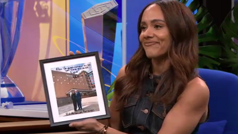 Alex Scott holding a picture of herself and Bob Wilson
