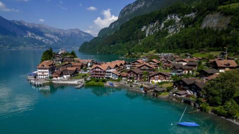 A town on the shore of Lake Brienz in the Swiss Alps with mountains behind